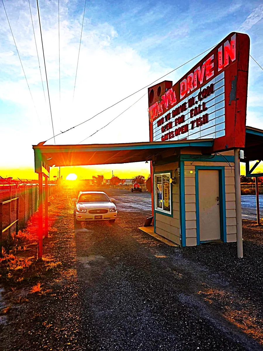 The Tru-Vu box office and marquee lit at sunset, a car pulling up to the gate