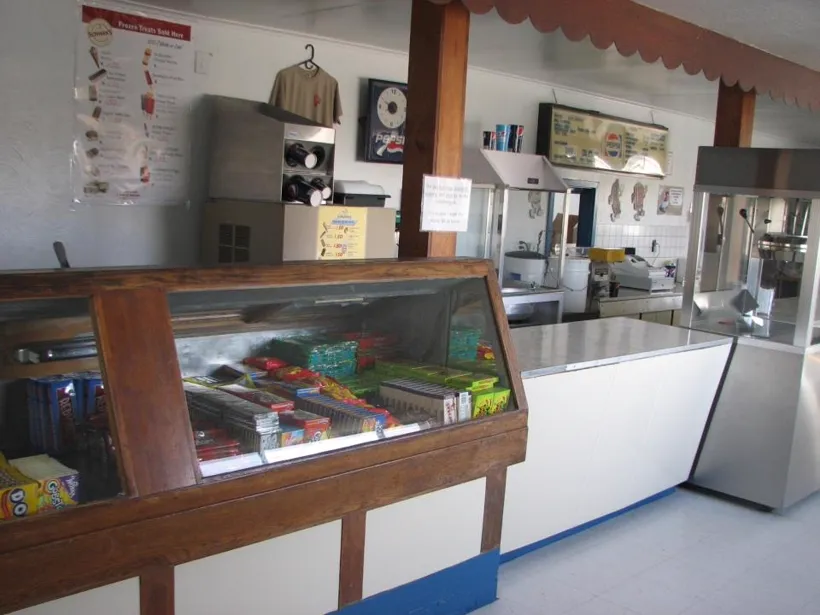 Inside the Tru-Vu concession stand — candy case, popcorn machine, and menu boards